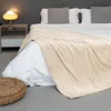 A cozy bedroom scene with a bed covered in a soft, textured blanket. Produktbild-Vorschau