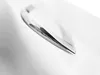 A close-up, black and white shot of a chrome handle on a white surface, likely a bathtub. Produktbild-Vorschau
