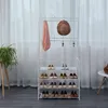 A white garment rack with shelves for shoes, a scarf, and a hat, placed indoors in front of a sheer curtain. Anteprima dell’immagine prodotto