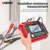 A hand holding a red insulation resistance tester near some plumbing and electrical wiring. Podgląd zdjęcia produktu