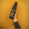 A hand emerges from a hole in a yellow surface, holding a black water bottle with Hufflepuff branding. Náhľad obrázku produktu
