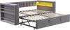 A grey sofa bed with its mattress frame extended, showing the internal mechanism and wooden slats. It has built-in shelves on one side and a yellow illuminated compartment on the other. Podgląd zdjęcia produktu