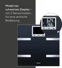 A black digital scale with a close-up inset showing the display. Produktbild-Vorschau