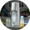 A kitchen counter with a SodaStream machine, a glass of sparkling water with lime, and a bottle of SodaStream syrup. Produktbild-Vorschau