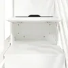 A close-up view of a white wooden cabinet with an open shelf. Produktbild-Vorschau