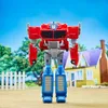 A toy robot stands in front of a house and trees. Podgląd zdjęcia produktu