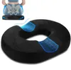 A black ring cushion is shown in the foreground, with a diagram of a person sitting on a similar cushion in the background, illustrating spinal alignment. Produktbild-Vorschau