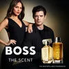 A man and a woman are posing with two bottles of Hugo Boss The Scent perfume. Anteprima dell’immagine prodotto