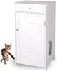 A white cat litter box enclosure with a drawer and a decorative cut-out on the side, shown next to a tabby cat. Náhled obrázku produktu