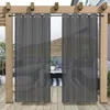 Outdoor curtains hanging on a wooden pergola, with a seating area visible behind them. Produktbild-Vorschau