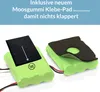 Two green battery packs with black foam pads on them. Text overlays the top of the image. Produktbild-Vorschau