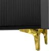 A close-up view of the bottom corner of a black ribbed cabinet with gold metal legs. Anteprima dell’immagine prodotto