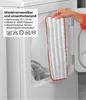 A hand holds a mop head in front of an open washing machine. Produktbild-Vorschau