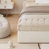 A close-up view of a bed and a beanbag chair in a bedroom setting. Anteprima dell’immagine prodotto
