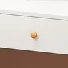 A close-up of a drawer knob on a white surface, with a brown surface below. Produktbild-Vorschau