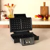 A waffle maker is open on a kitchen counter. Anteprima dell’immagine prodotto