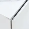 A close-up view of the corner of a white marble-look nightstand with two drawers. Anteprima dell’immagine prodotto