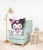 A plush toy is sitting on a chair in a room with a lamp and side tables. Podgląd zdjęcia produktu