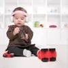 A baby wearing headphones plays with toys on the floor in front of a white shelving unit. Anteprima dell’immagine prodotto