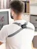 A man is sitting at a desk, wearing a posture trainer, and looking at a computer screen. Podgląd zdjęcia produktu