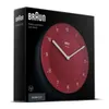A red Braun wall clock is shown on its black packaging. Náhľad obrázku produktu