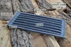 A cast iron grate is placed on a pile of firewood. Anteprima dell’immagine prodotto