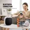 A woman is using her smartphone to control a diffuser in a living room setting. Náhled obrázku produktu