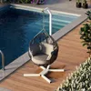 A hanging chair is placed on a wooden deck next to a swimming pool. Podgląd zdjęcia produktu