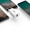A white USB wall charger is shown plugged into a smartphone, with two other smartphones in the background. Anteprima dell’immagine prodotto