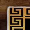A close-up view of a rug with a Greek key pattern. Produktbild-Vorschau