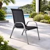 An outdoor chair by a swimming pool with lush greenery and a view of the sea. Anteprima dell’immagine prodotto
