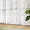 A close-up view of a white lace curtain hanging in a window. Náhled obrázku produktu