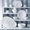 A collection of white ceramic tableware displayed on shelves against a striped background. Anteprima dell’immagine prodotto