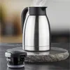 A stainless steel insulated carafe with its lid next to it, placed on a stone slab. Produktbild-Vorschau