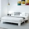 A white bed frame with white bedding and grey pillows in a bright, minimalist bedroom. Náhled obrázku produktu