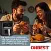 A couple happily eating fried chicken in front of an air fryer. Produktbild-Vorschau