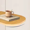 Helles Holz-Schwebeboard mit einem Buch und einer gerippten beigen Kaffeetasse mit Löffel darauf Voir les images du produit