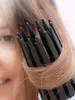 A close-up shot of a black hair dryer with hair wrapped around it, with a person's face blurred in the background. Náhled obrázku produktu