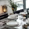 A beautifully set dining table with plates, glasses, and festive decorations, suggesting a winter or holiday meal. Náhled obrázku produktu