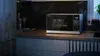 A modern kitchen counter with a Sharp microwave, kitchen utensils, and a plant. Produktbild-Vorschau