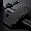 A black leather flip case for a smartphone is displayed on a dark surface, with a smartwatch in the background. Produktbild-Vorschau
