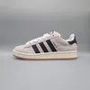 A side view of an Adidas sneaker against a plain gray background. Voir les images du produit