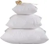 A stack of three white pillows with a decorative dried flower on top. Náhľad obrázku produktu
