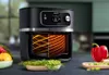A Philips air fryer is shown on a countertop with fresh vegetables and fruits around it. Podgląd zdjęcia produktu
