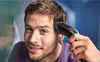 A man is cutting his hair with an electric hair clipper. Produktbild-Vorschau