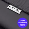 A close-up of a gray fabric with a white tag and a blue circular overlay. Produktbild-Vorschau
