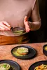 A person is dusting a dessert with green powder. Náhľad obrázku produktu