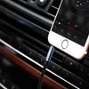 A close-up shot of a smartphone plugged into a car's audio system with an AUX cable. Produktbild-Vorschau