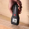 A hand holds a digital moisture meter, with its pins inserted into a piece of wood. Produktbild-Vorschau