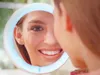 A woman looking into a lighted makeup mirror. Náhľad obrázku produktu